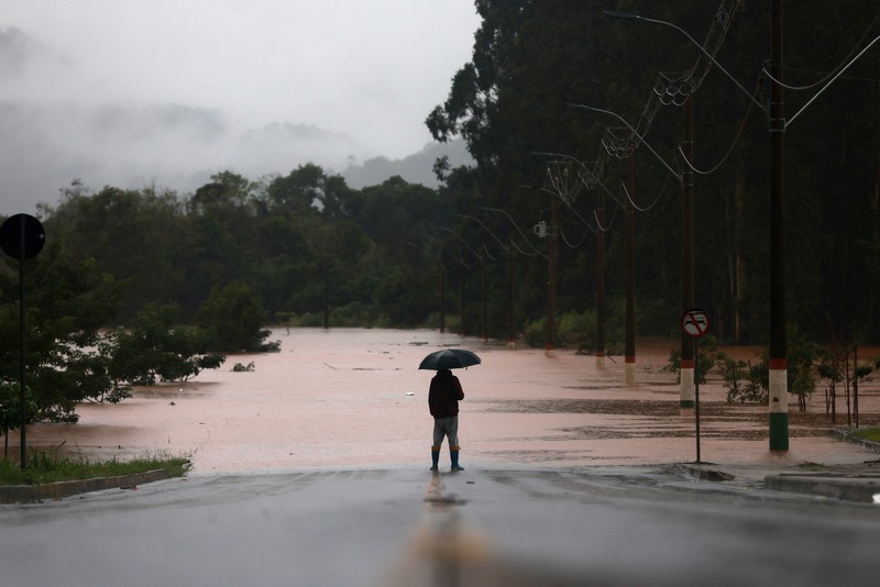 Orang-orang menyelamatkan barang-barang mereka di daerah banjir di sebelah Sungai Taquari saat hujan lebat di kota Encantado di Rio Grande do Sul, Brasil, 1 Mei 2024. (REUTERS/Diego Vara)