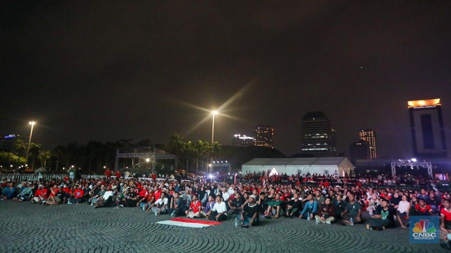 Warga menyaksikan pertandingan Timnas U-23 Indonesia melawan Timnas U-23 Irak dalam perebutan Juara 3 Piala Asia U-23 Piala Asia 2024 melalui layar saat nonton bareng (nobar) di kawasan Monas, Jakarta, Kamis (2/5/2024) malam. (CNBC Indonesia/Faisal Rahman)