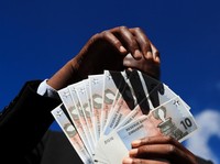Seorang pria menunjukkan mata uang baru Zimbabwe yang didukung emas setelah menarik uang dari bank lokal di Harare, Zimbabwe, 30 April 2024. (REUTERS/Philimon Bulawayo)