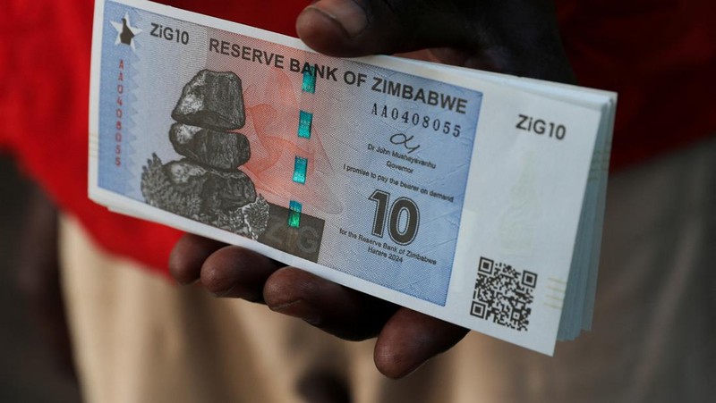 Seorang wanita memegang uang kertas dan koin Zimbabwe baru yang disebut ZiG, di jalan-jalan Harare, Zimbabwe, Selasa, 30 April 2024. Zimbabwe mulai mengedarkan uang kertas dan koin untuk mata uang baru lainnya pada hari Selasa dalam upaya terbarunya untuk menyelesaikan permasalahan jangka panjang dan terkadang krisis moneter membingungkan yang membuat pemerintah mencoba koin emas dan mata uang digital di antara ide-ide lainnya. (AP Photo/Tsvangirayi Mukwazhi)