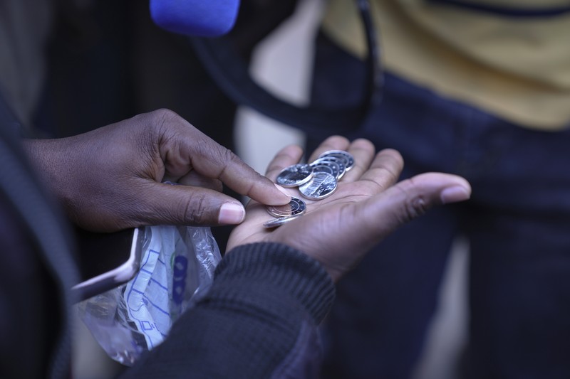 Seorang wanita memegang uang kertas dan koin Zimbabwe baru yang disebut ZiG, di jalan-jalan Harare, Zimbabwe, Selasa, 30 April 2024. Zimbabwe mulai mengedarkan uang kertas dan koin untuk mata uang baru lainnya pada hari Selasa dalam upaya terbarunya untuk menyelesaikan permasalahan jangka panjang dan terkadang krisis moneter membingungkan yang membuat pemerintah mencoba koin emas dan mata uang digital di antara ide-ide lainnya. (AP Photo/Tsvangirayi Mukwazhi)