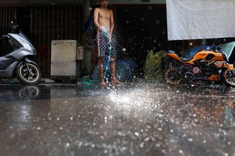 Orang-orang berjalan dengan payung melewati percikan air ketika pihak berwenang Thailand mengatakan bahwa orang-orang meninggal karena serangan panas tahun ini dan memperingatkan untuk menghindari aktivitas di luar ruangan, di Bangkok, Thailand, 5 Mei 2024. Orang-orang berjalan dengan payung melewati percikan air ketika pihak berwenang Thailand mengatakan bahwa orang-orang meninggal karena serangan panas tahun ini dan memperingatkan untuk menghindari aktivitas di luar ruangan, di Bangkok, Thailand, 5 Mei 2024. (REUTERS/Chalinee Thirasupa)