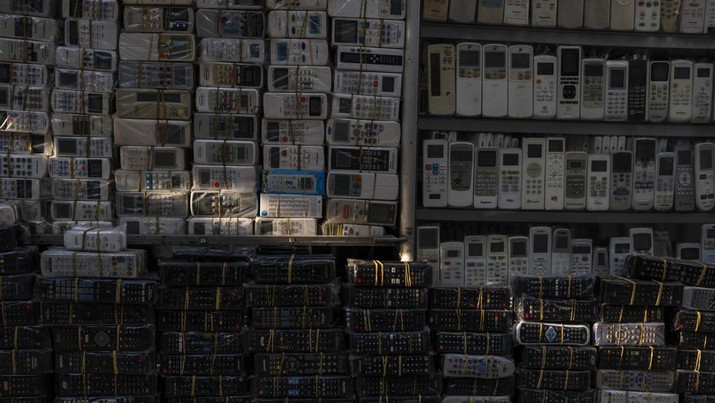 Remote control bekas untuk berbagai peralatan rumah tangga diterangi sinar matahari sore di pasar Nhat Tao, pasar daur ulang informal terbesar di Kota Ho Chi Minh, Vietnam, Minggu, 28 Januari 2024. (AP Photo/Jae C. Hong)
