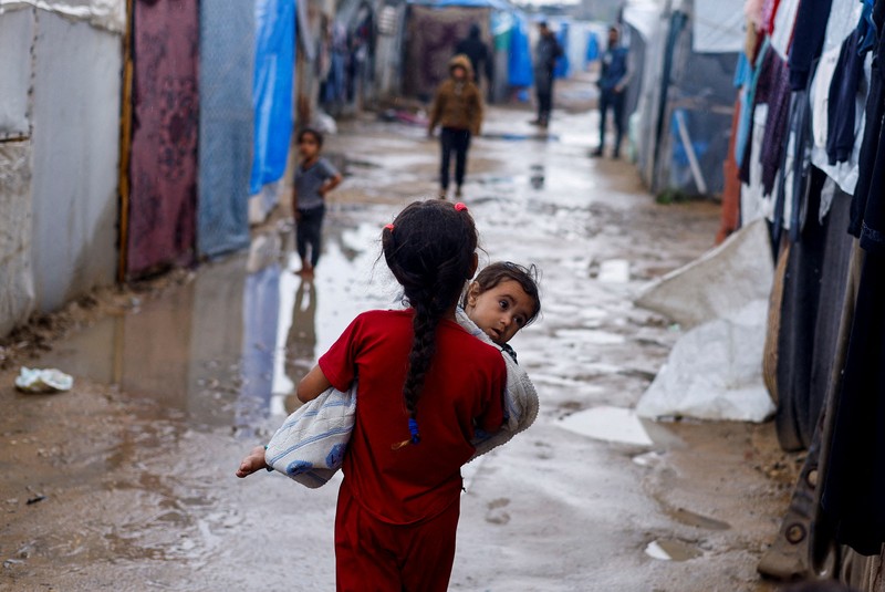 Orang-orang bergegas mengambil kantong tepung dari truk setelah militer Israel mulai mengevakuasi warga sipil Palestina menjelang ancaman serangan di Rafah, di tengah konflik yang sedang berlangsung antara Israel dan Hamas, di Rafah, di selatan Jalur Gaza 6 Mei 2024. Orang-orang bergegas mengambil kantong tepung dari truk setelah militer Israel mulai mengevakuasi warga sipil Palestina menjelang ancaman serangan di Rafah, di tengah konflik yang sedang berlangsung antara Israel dan Hamas, di Rafah, di selatan Jalur Gaza 6 Mei 2024. (REUTERS/Hatem Khaled)