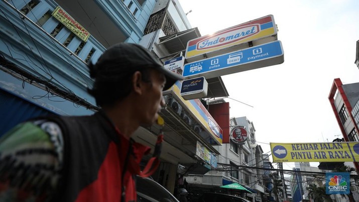Aktivitas seorang warga menjaga kendaraan di salahsatu minimarket di kawasan Jakarta, Rabu (8/4/2024). (CNBC Indonesia/Tri Susilo)
