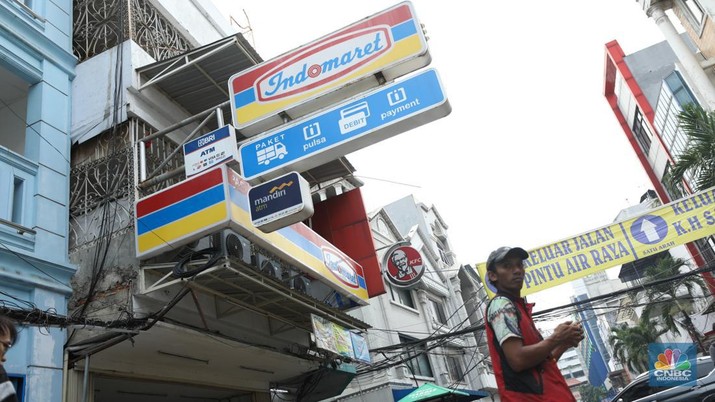 Aktivitas seorang warga menjaga kendaraan di salahsatu minimarket di kawasan Jakarta, Rabu (8/4/2024). (CNBC Indonesia/Tri Susilo)