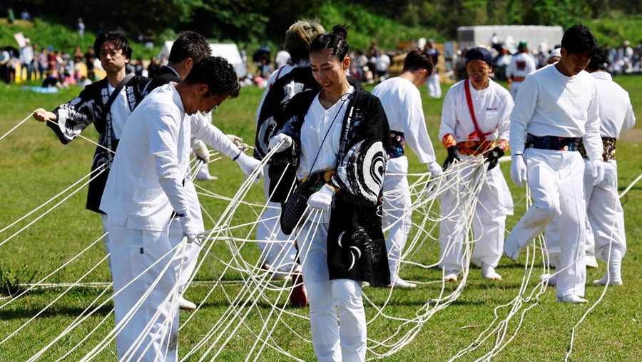 Para peserta bersiap menerbangkan layang-layang besar selama Oodako Matsuri, festival layang-layang raksasa, di Sagamihara, selatan Tokyo, Jepang, 4 Mei 2024. Festival tahunan ini telah diwariskan selama lebih dari satu abad sebagai bentuk doa untuk membantu memastikan panen yang bagus. (REUTERS/Kim Kyung-Hoon)