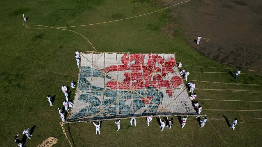 Para peserta bersiap menerbangkan layang-layang besar selama Oodako Matsuri, festival layang-layang raksasa, di Sagamihara, selatan Tokyo, Jepang, 4 Mei 2024. Festival tahunan ini telah diwariskan selama lebih dari satu abad sebagai bentuk doa untuk membantu memastikan panen yang bagus. (REUTERS/Kim Kyung-Hoon)