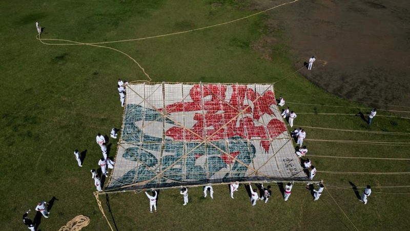 Para peserta bersiap menerbangkan layang-layang besar selama Oodako Matsuri, festival layang-layang raksasa, di Sagamihara, selatan Tokyo, Jepang, 4 Mei 2024. Festival tahunan ini telah diwariskan selama lebih dari satu abad sebagai bentuk doa untuk membantu memastikan panen yang bagus. (REUTERS/Kim Kyung-Hoon)