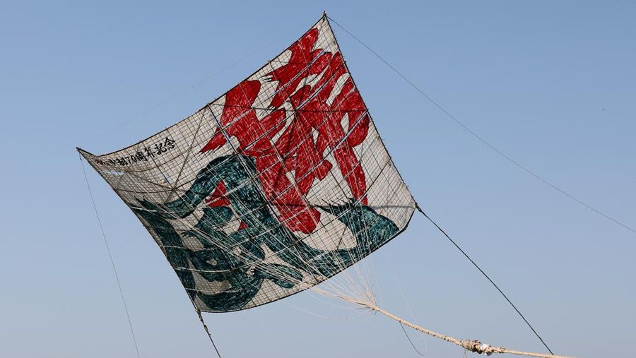 Para peserta bersiap menerbangkan layang-layang besar selama Oodako Matsuri, festival layang-layang raksasa, di Sagamihara, selatan Tokyo, Jepang, 4 Mei 2024. Festival tahunan ini telah diwariskan selama lebih dari satu abad sebagai bentuk doa untuk membantu memastikan panen yang bagus. (REUTERS/Kim Kyung-Hoon)
