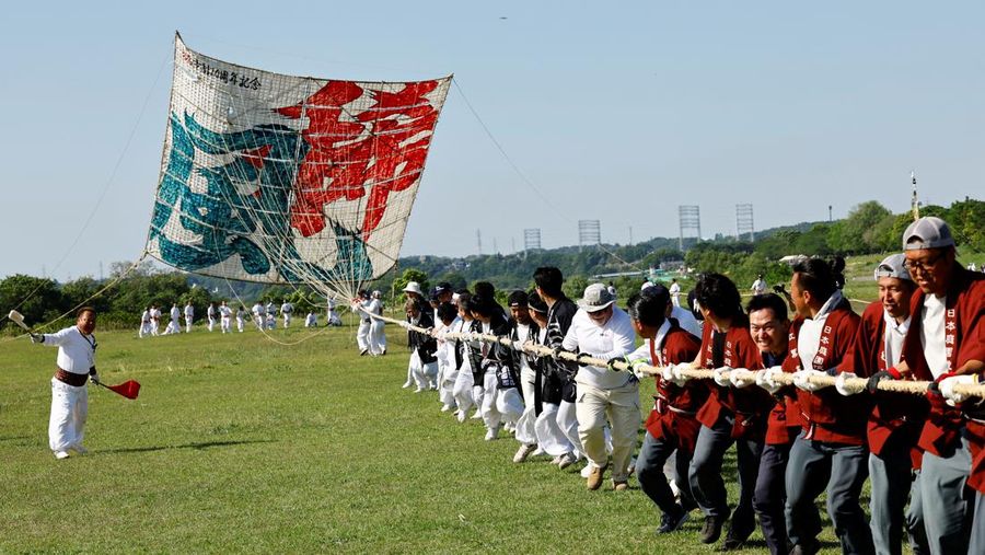 Para peserta bersiap menerbangkan layang-layang besar selama Oodako Matsuri, festival layang-layang raksasa, di Sagamihara, selatan Tokyo, Jepang, 4 Mei 2024. Festival tahunan ini telah diwariskan selama lebih dari satu abad sebagai bentuk doa untuk membantu memastikan panen yang bagus. (REUTERS/Kim Kyung-Hoon)