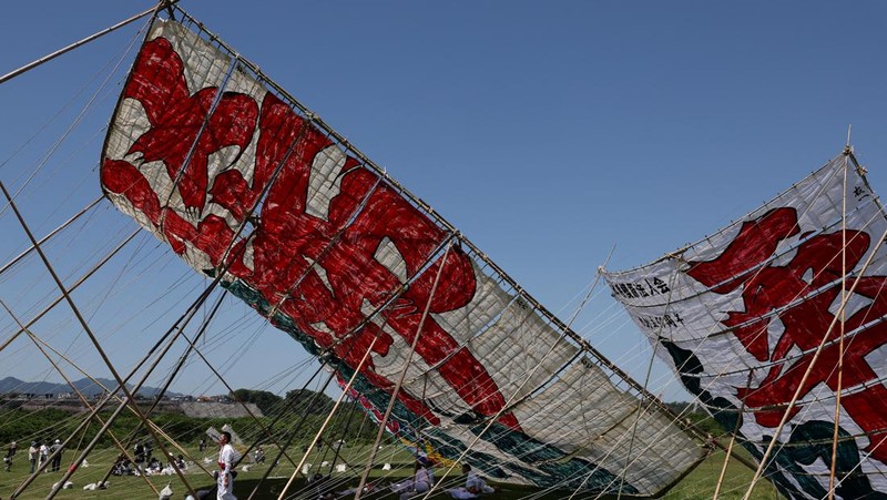 Para peserta bersiap menerbangkan layang-layang besar selama Oodako Matsuri, festival layang-layang raksasa, di Sagamihara, selatan Tokyo, Jepang, 4 Mei 2024. Festival tahunan ini telah diwariskan selama lebih dari satu abad sebagai bentuk doa untuk membantu memastikan panen yang bagus. (REUTERS/Kim Kyung-Hoon)