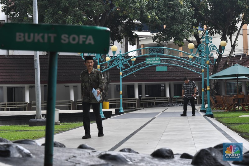 Seorang petugas melintas di samping miniatur Bukit Sofa-Marwah Asrama Haji Embarkasi Bekasi, Jawa Barat, Rabu (8/6/2024). (CNBC Indonesia/Muhammad Sabki)