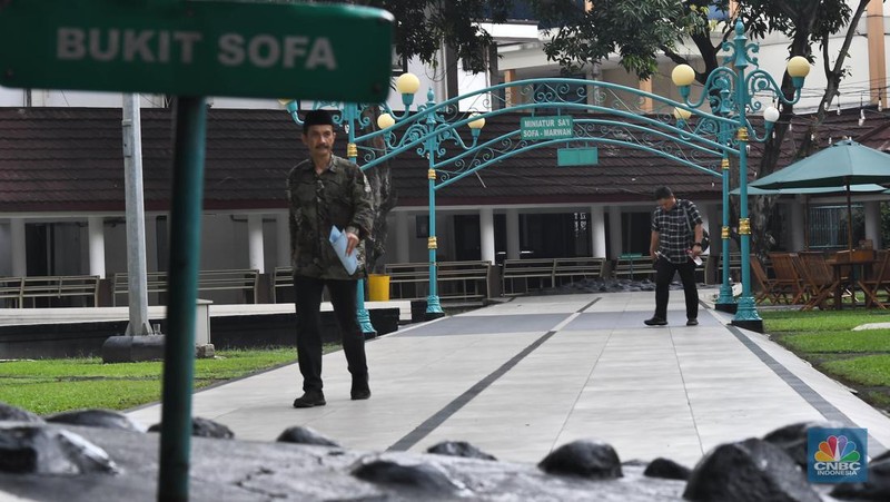 Seorang petugas melintas di samping miniatur Bukit Sofa-Marwah Asrama Haji Embarkasi Bekasi, Jawa Barat, Rabu (8/6/2024). (CNBC Indonesia/Muhammad Sabki)
