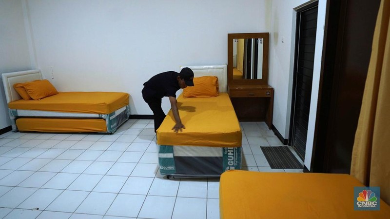 Seorang petugas melintas di samping miniatur Bukit Sofa-Marwah Asrama Haji Embarkasi Bekasi, Jawa Barat, Rabu (8/6/2024). (CNBC Indonesia/Muhammad Sabki)
