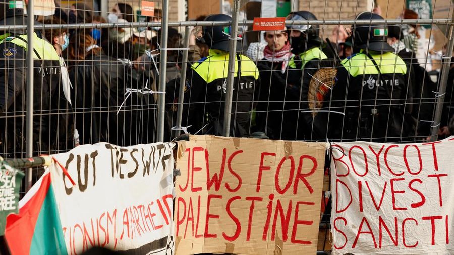 Police officers stand next to pro-Palestinian protesters outside the University of Amsterdam during a protest against the ongoing conflict between Israel and the Palestinian Islamist group Hamas in Gaza, in Amsterdam, Netherlands, May 8 2024. REUTERS/Piroschka van de Wouw