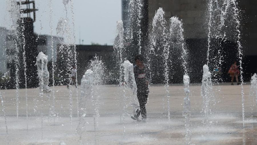 Orang-orang menutupi diri mereka dengan payung di samping orang lain saat mereka berjalan di trotoar saat suhu tinggi, di Mexico City, Meksiko 9 Mei 2024. (REUTERS/Henry Romero)