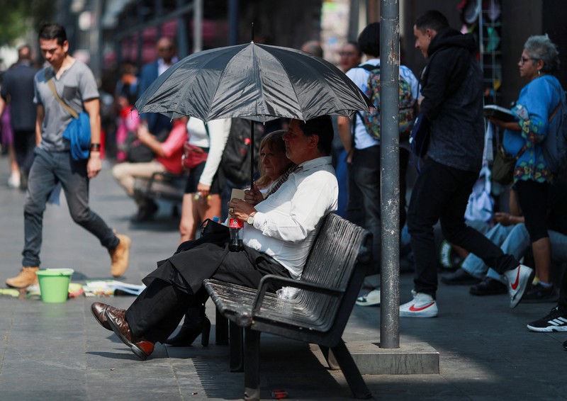 Orang-orang menutupi diri mereka dengan payung di samping orang lain saat mereka berjalan di trotoar saat suhu tinggi, di Mexico City, Meksiko 9 Mei 2024. Orang-orang menutupi diri mereka dengan payung di samping orang lain saat mereka berjalan di trotoar saat suhu tinggi, di Mexico City, Meksiko 9 Mei 2024. (REUTERS/Henry Romero)