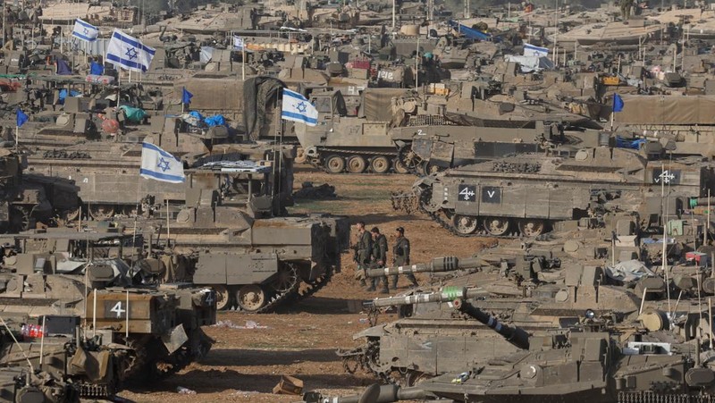 Tentara Israel berjalan di tengah kendaraan militer, di tengah konflik yang sedang berlangsung antara Israel dan kelompok Islam Palestina Hamas, dekat Perbatasan Israel-Gaza, di Israel selatan, 9 Mei 2024. (REUTERS/Amir Cohen)
