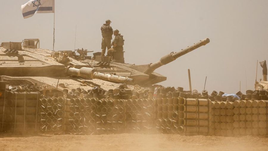 Tentara Israel berjalan di tengah kendaraan militer, di tengah konflik yang sedang berlangsung antara Israel dan kelompok Islam Palestina Hamas, dekat Perbatasan Israel-Gaza, di Israel selatan, 9 Mei 2024. (REUTERS/Amir Cohen)