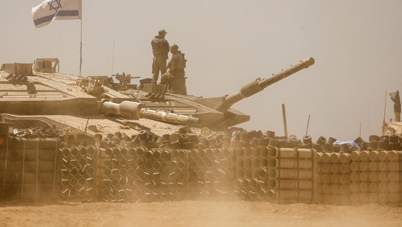 Tentara Israel berjalan di tengah kendaraan militer, di tengah konflik yang sedang berlangsung antara Israel dan kelompok Islam Palestina Hamas, dekat Perbatasan Israel-Gaza, di Israel selatan, 9 Mei 2024. (REUTERS/Amir Cohen)