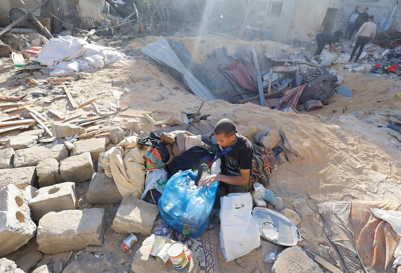 Warga Palestina memeriksa lokasi serangan Israel di sebuah rumah, di tengah konflik yang sedang berlangsung antara Israel dan kelompok Islam Palestina Hamas, di Rafah, di selatan Jalur Gaza, 8 Mei 2024. (REUTERS/Mohammed Salem)