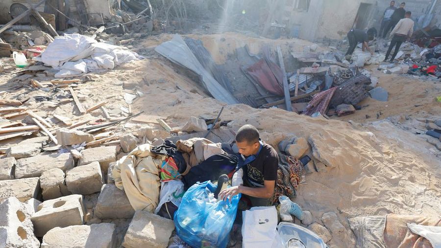 Warga Palestina memeriksa lokasi serangan Israel di sebuah rumah, di tengah konflik yang sedang berlangsung antara Israel dan kelompok Islam Palestina Hamas, di Rafah, di selatan Jalur Gaza, 8 Mei 2024. (REUTERS/Mohammed Salem)