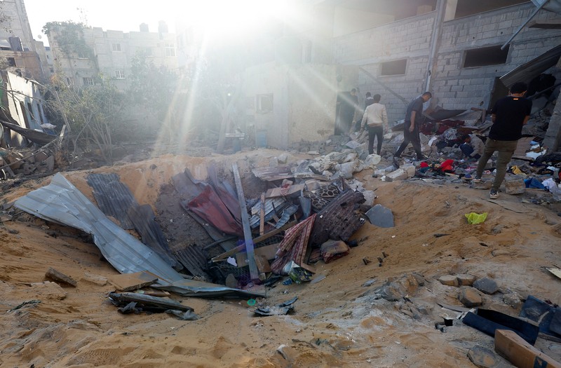 Warga Palestina memeriksa lokasi serangan Israel di sebuah rumah, di tengah konflik yang sedang berlangsung antara Israel dan kelompok Islam Palestina Hamas, di Rafah, di selatan Jalur Gaza, 8 Mei 2024. (REUTERS/Mohammed Salem)