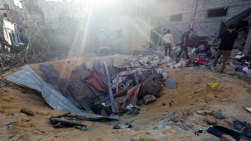 Warga Palestina memeriksa lokasi serangan Israel di sebuah rumah, di tengah konflik yang sedang berlangsung antara Israel dan kelompok Islam Palestina Hamas, di Rafah, di selatan Jalur Gaza, 8 Mei 2024. (REUTERS/Mohammed Salem)