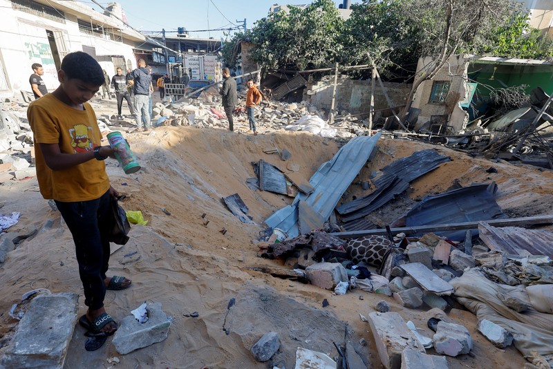 Warga Palestina memeriksa lokasi serangan Israel di sebuah rumah, di tengah konflik yang sedang berlangsung antara Israel dan kelompok Islam Palestina Hamas, di Rafah, di selatan Jalur Gaza, 8 Mei 2024. (REUTERS/Mohammed Salem)