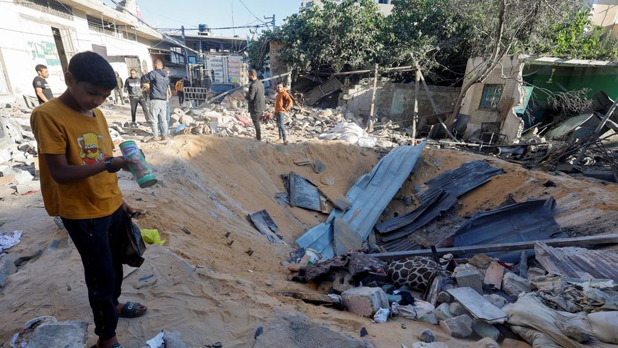 Warga Palestina memeriksa lokasi serangan Israel di sebuah rumah, di tengah konflik yang sedang berlangsung antara Israel dan kelompok Islam Palestina Hamas, di Rafah, di selatan Jalur Gaza, 8 Mei 2024. (REUTERS/Mohammed Salem)