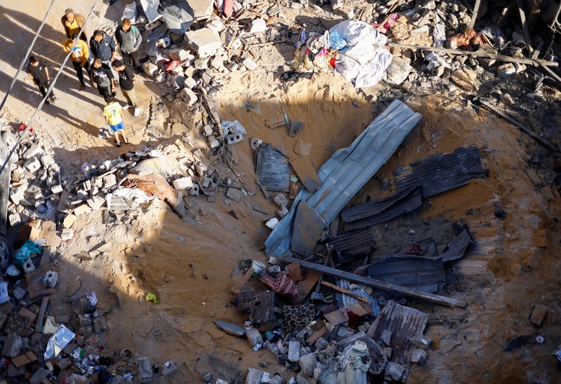 Warga Palestina memeriksa lokasi serangan Israel di sebuah rumah, di tengah konflik yang sedang berlangsung antara Israel dan kelompok Islam Palestina Hamas, di Rafah, di selatan Jalur Gaza, 8 Mei 2024. (REUTERS/Mohammed Salem)