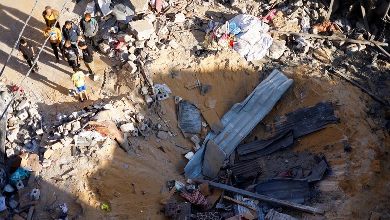 Warga Palestina memeriksa lokasi serangan Israel di sebuah rumah, di tengah konflik yang sedang berlangsung antara Israel dan kelompok Islam Palestina Hamas, di Rafah, di selatan Jalur Gaza, 8 Mei 2024. (REUTERS/Mohammed Salem)