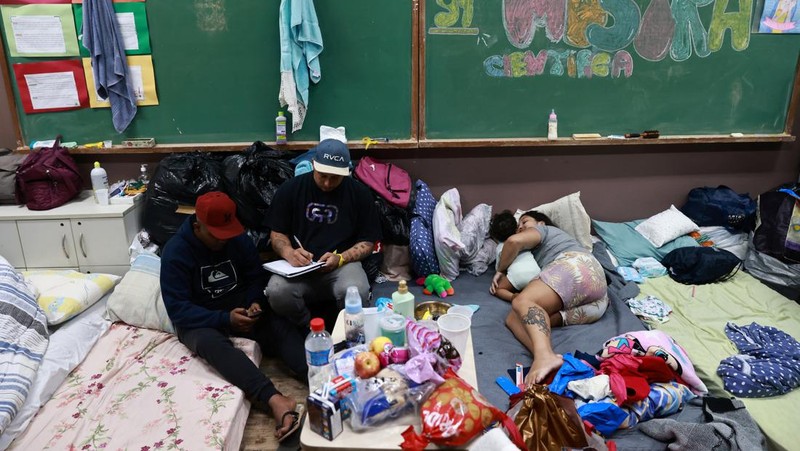 Warga yang dievakuasi dari kawasan banjir beristirahat di gym yang digunakan sebagai tempat berlindung di Porto Alegre, negara bagian Rio Grande do Sul, Brasil, 10 Mei 2024. (REUTERS/Diego Vara)
