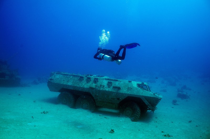Seorang penyelam berenang di samping kendaraan militer yang tenggelam di Museum Militer Bawah Air di Aqaba, Yordania, 7 Mei 2024. (REUTERS/Stelios Misinas)     TPX IMAGES OF THE DAY
