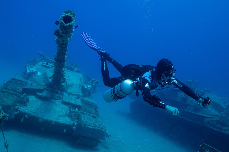 Seorang penyelam berenang di samping kendaraan militer yang tenggelam di Museum Militer Bawah Air di Aqaba, Yordania, 7 Mei 2024. (REUTERS/Stelios Misinas)     TPX IMAGES OF THE DAY