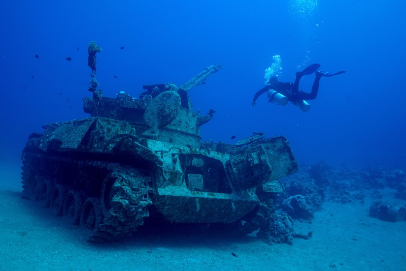 Seorang penyelam berenang di samping kendaraan militer yang tenggelam di Museum Militer Bawah Air di Aqaba, Yordania, 7 Mei 2024. (REUTERS/Stelios Misinas)     TPX IMAGES OF THE DAY