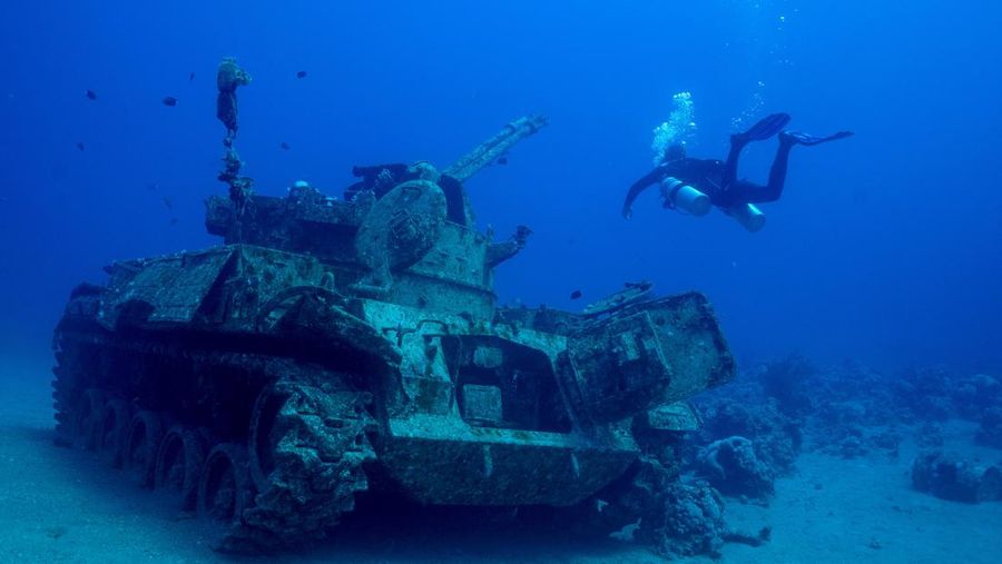 Seorang penyelam berenang di samping kendaraan militer yang tenggelam di Museum Militer Bawah Air di Aqaba, Yordania, 7 Mei 2024. (REUTERS/Stelios Misinas)     TPX IMAGES OF THE DAY
