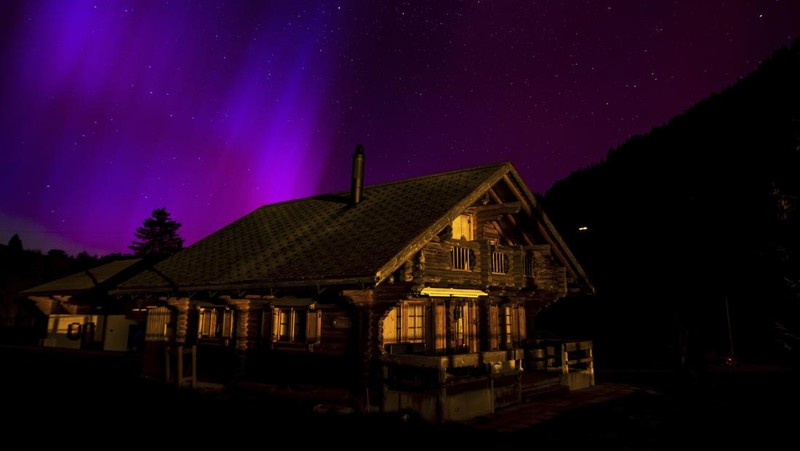 In this image taken with a long exposure, cars pass by as people look at the night sky towards the northern lights, or Aurora Borealis, on Friday, May 10, 2024, in Estacada, Ore. The National Oceanic and Atmospheric Administration issued a rare severe geomagnetic storm warning when a solar outburst reached Earth on Friday afternoon, hours sooner than anticipated. The effects were due to last through the weekend and possibly into next week. (AP Photo/Jenny Kane)