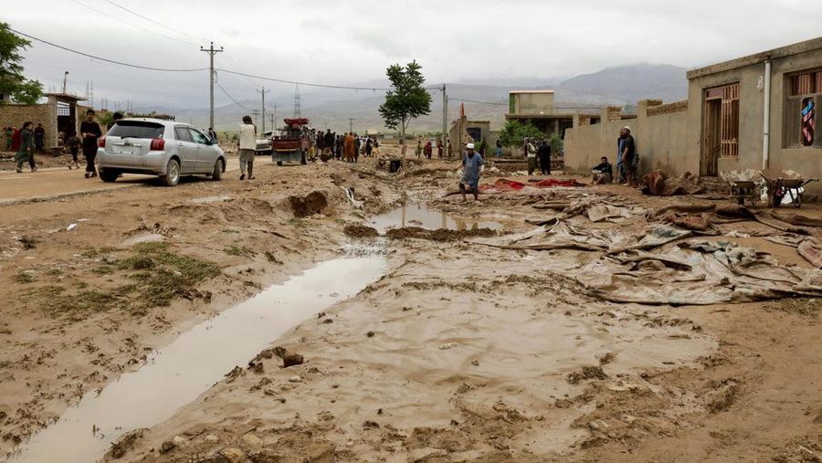 Afghan relatives offer prayers during a burial ceremony, near the graves of victim who lost their lives following flash floods after heavy rainfall at a village in Baghlan-e-Markazi district of Baghlan province on May 11, 2024. More than 300 people were killed in flash flooding in Afghanistan's northern province of Baghlan, the World Food Programme said on May 11. (Photo by Atif Aryan / AFP)