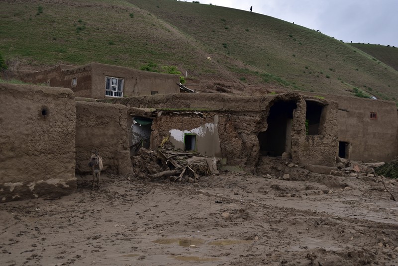 Afghan relatives offer prayers during a burial ceremony, near the graves of victim who lost their lives following flash floods after heavy rainfall at a village in Baghlan-e-Markazi district of Baghlan province on May 11, 2024. More than 300 people were killed in flash flooding in Afghanistan's northern province of Baghlan, the World Food Programme said on May 11. (Photo by Atif Aryan / AFP)
