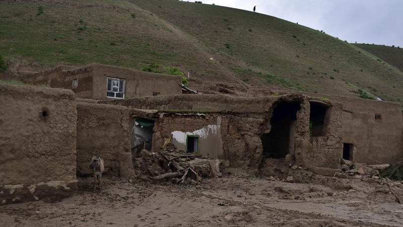 Afghan relatives offer prayers during a burial ceremony, near the graves of victim who lost their lives following flash floods after heavy rainfall at a village in Baghlan-e-Markazi district of Baghlan province on May 11, 2024. More than 300 people were killed in flash flooding in Afghanistan's northern province of Baghlan, the World Food Programme said on May 11. (Photo by Atif Aryan / AFP)