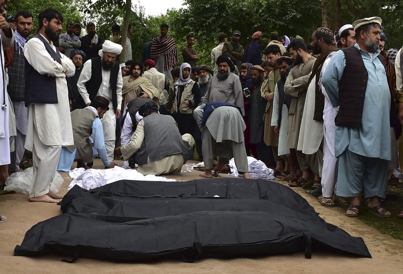 Afghan relatives offer prayers during a burial ceremony, near the graves of victim who lost their lives following flash floods after heavy rainfall at a village in Baghlan-e-Markazi district of Baghlan province on May 11, 2024. More than 300 people were killed in flash flooding in Afghanistan's northern province of Baghlan, the World Food Programme said on May 11. (Photo by Atif Aryan / AFP)