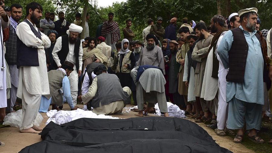 Afghan relatives offer prayers during a burial ceremony, near the graves of victim who lost their lives following flash floods after heavy rainfall at a village in Baghlan-e-Markazi district of Baghlan province on May 11, 2024. More than 300 people were killed in flash flooding in Afghanistan's northern province of Baghlan, the World Food Programme said on May 11. (Photo by Atif Aryan / AFP)