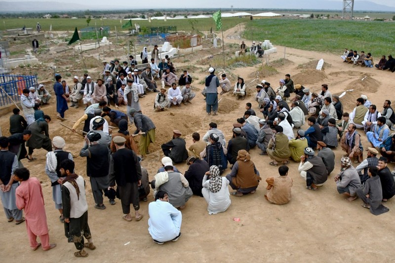 AFGHANISTAN-WEATHER-FLOOD Afghan relatives offer prayers during a burial ceremony, near the graves of victim who lost their lives following flash floods after heavy rainfall at a village in Baghlan-e-Markazi district of Baghlan province on May 11, 2024. More than 300 people were killed in flash flooding in Afghanistan's northern province of Baghlan, the World Food Programme said on May 11. (Photo by Atif Aryan / AFP)