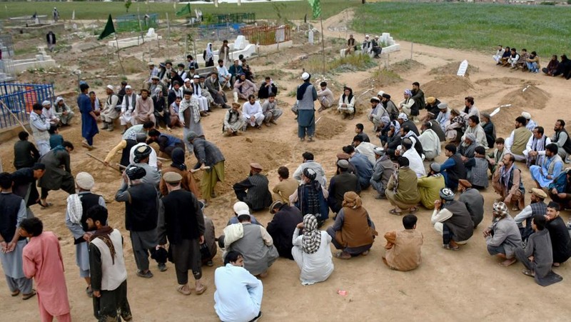 Afghan relatives offer prayers during a burial ceremony, near the graves of victim who lost their lives following flash floods after heavy rainfall at a village in Baghlan-e-Markazi district of Baghlan province on May 11, 2024. More than 300 people were killed in flash flooding in Afghanistan's northern province of Baghlan, the World Food Programme said on May 11. (Photo by Atif Aryan / AFP)