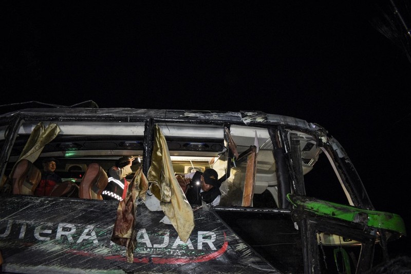 INDONESIA-ACCIDENT-BUS Officers check the debris and belongings of passengers after a bus crash that killed 11 people, according to local police, in Subang, West Java, on May 11, 2024. (Photo by Timur MATAHARI / AFP)