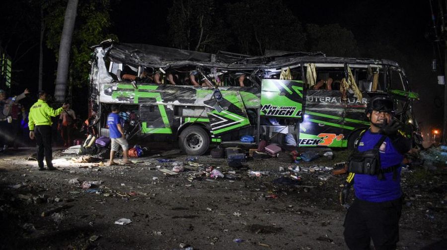 Officers check the debris and belongings of passengers after a bus crash that killed 11 people, according to local police, in Subang, West Java, on May 11, 2024. (Photo by Timur MATAHARI / AFP)