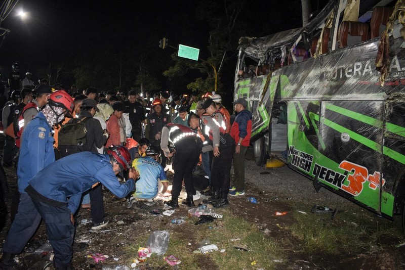 INDONESIA-ACCIDENT-BUS Officers check the debris and belongings of passengers after a bus crash that killed 11 people, according to local police, in Subang, West Java, on May 11, 2024. (Photo by Timur MATAHARI / AFP)