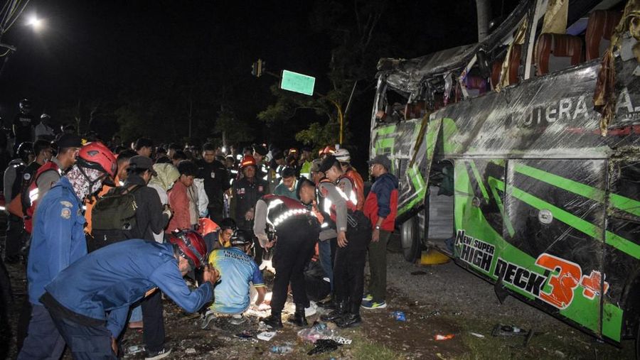 Officers check the debris and belongings of passengers after a bus crash that killed 11 people, according to local police, in Subang, West Java, on May 11, 2024. (Photo by Timur MATAHARI / AFP)
